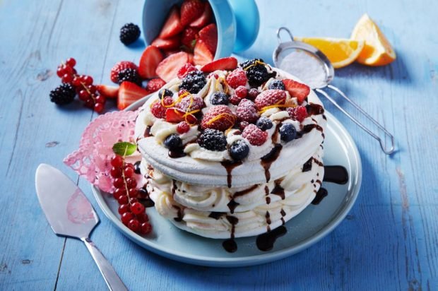 Pavlova cake with berries and chocolate glaze