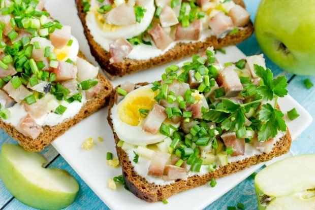 Sandwiches with herring and egg on black bread