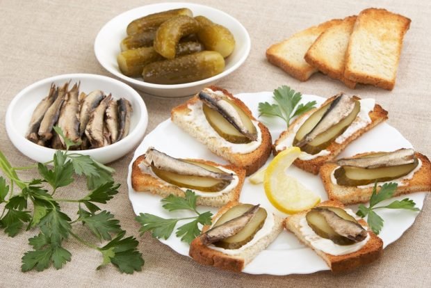 Sandwiches with sprats and white bread on the festive table