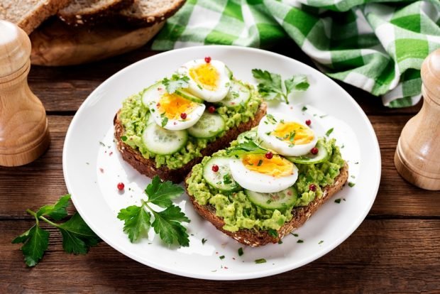 A sandwich with quail eggs and cucumbers 