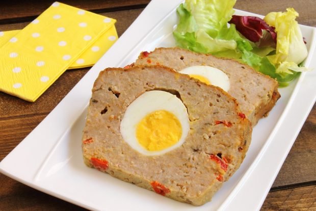 Minced meat loaf with egg and cheese in the oven