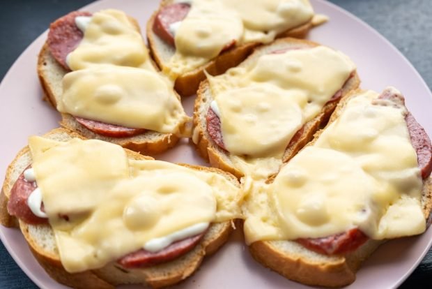 Hot sandwiches in a frying pan with sausage and cheese