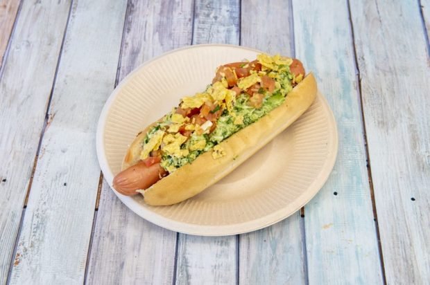 Hot dog with chips, tomatoes and avocado sauce 