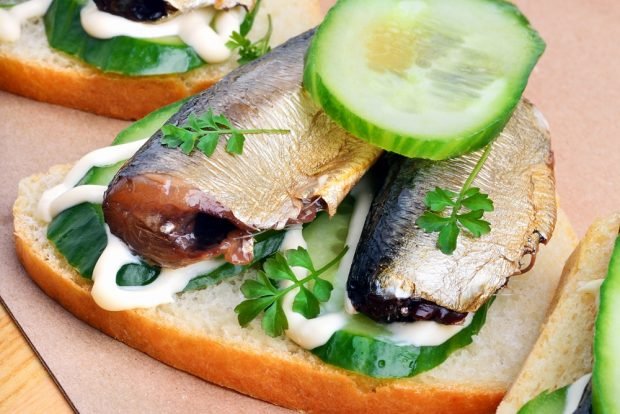 Sandwiches with sprats and cucumber on a loaf