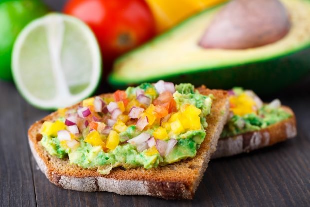 A sandwich with guacamole and salsa 