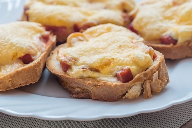 Hot sandwiches with sausage and cheese on a loaf in a frying pan