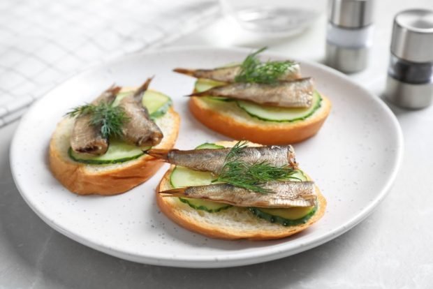 Sandwiches with sprats on a baguette