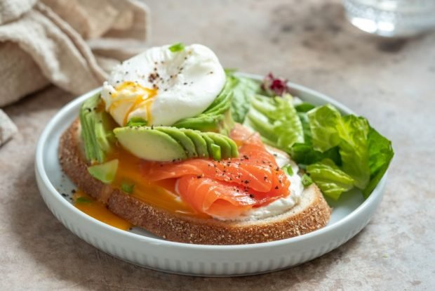 Sandwiches with avocado, poached egg and red fish