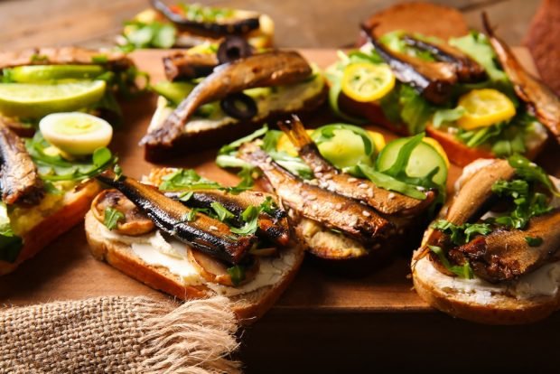 Sandwiches with sprats and a loaf for a festive table