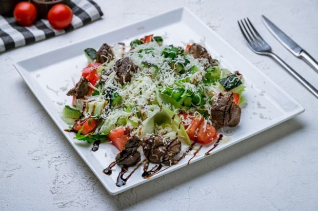 Salad of fried chicken liver, cucumbers and tomatoes 