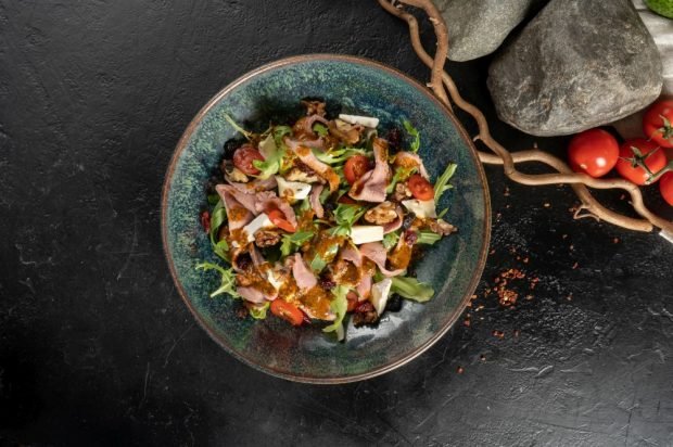 Festive salad with boiled pork, brie cheese and prunes