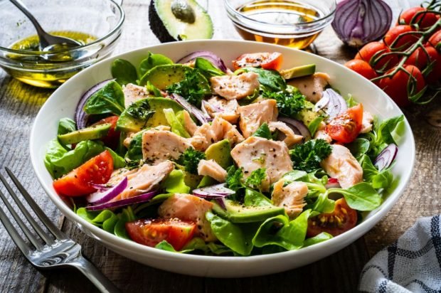 Salad with boiled red fish, avocado and cherry tomatoes 