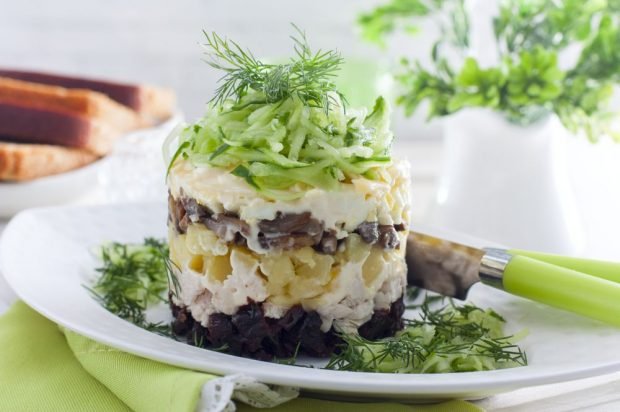 Puff salad with prunes, chicken and fried mushrooms 