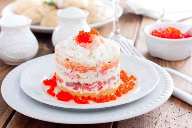 Layered salad of crab sticks, red fish, cheese and vegetables