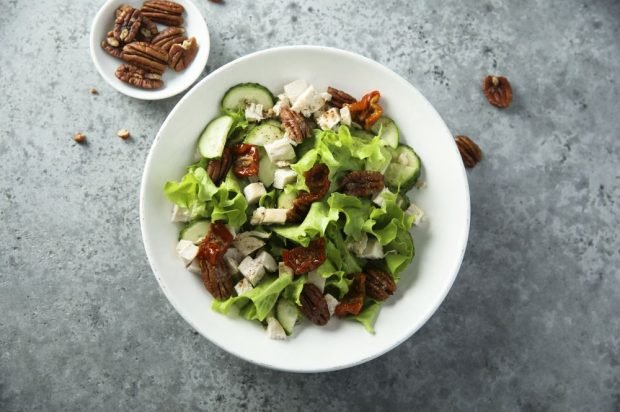 Meat salad with chicken, cucumbers, dried tomatoes and pecans