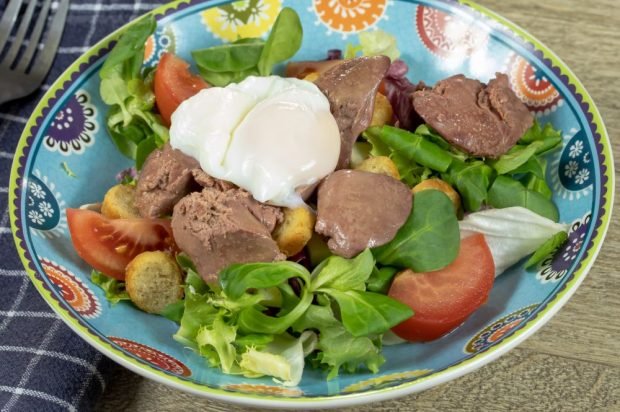 Chicken liver salad with tomatoes, crackers and poached egg