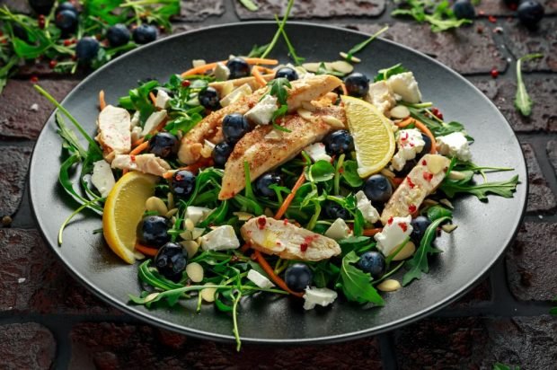 Salad of meat, feta, arugula and blueberries