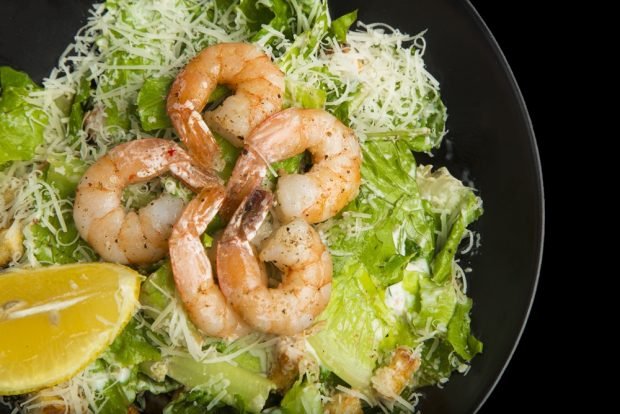 Caesar salad with shrimp and lemon 