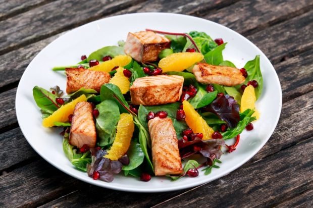 Salad with fried red fish, spinach and orange 