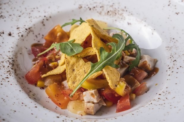 Salad with tomatoes, smoked chicken and chips