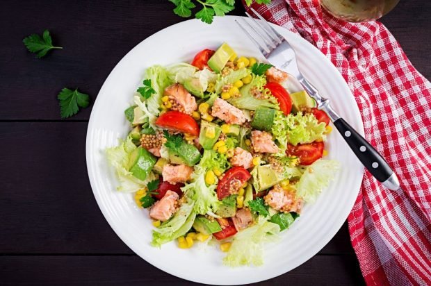 Salad with fried red fish, corn and avocado