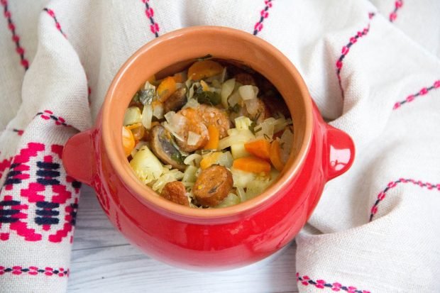 Vegetable stew with hunting sausages in pots