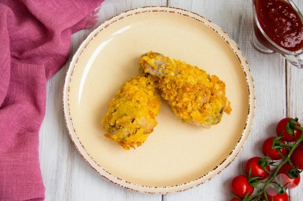 Breaded chicken legs in a frying pan