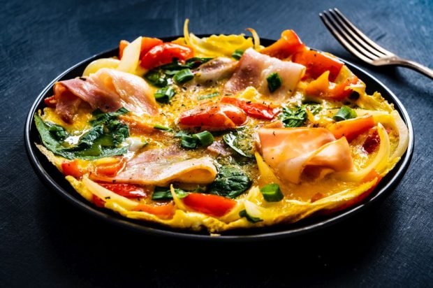 Omelet with cheese, bacon, spinach and vegetables