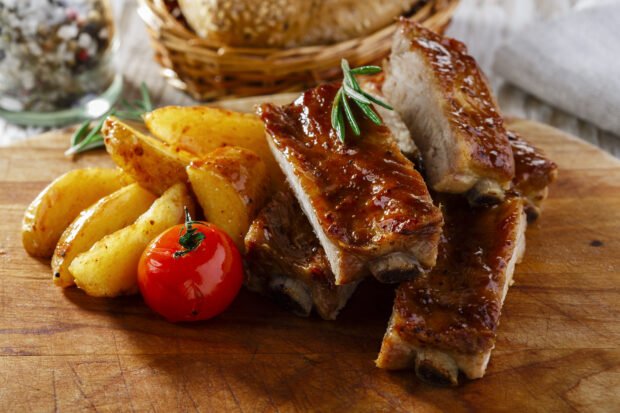 Pork ribs with potatoes and tomatoes in the oven