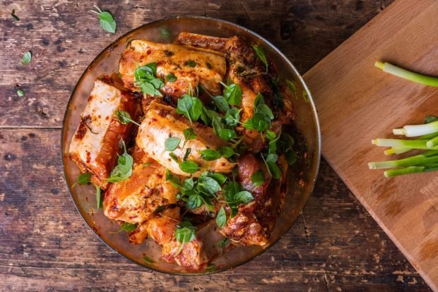 Pork ribs with onions in a frying pan 