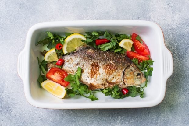 Crucian carp with tomatoes and herbs in the oven