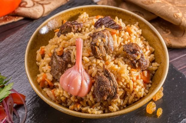 Meat pilaf with pickled garlic in a slow cooker 