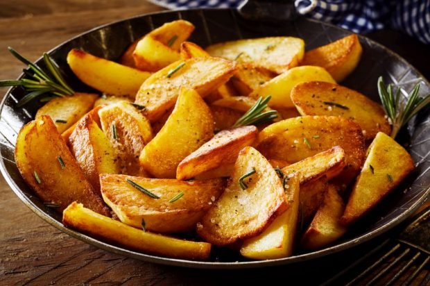 Rustic potatoes with rosemary in a frying pan 