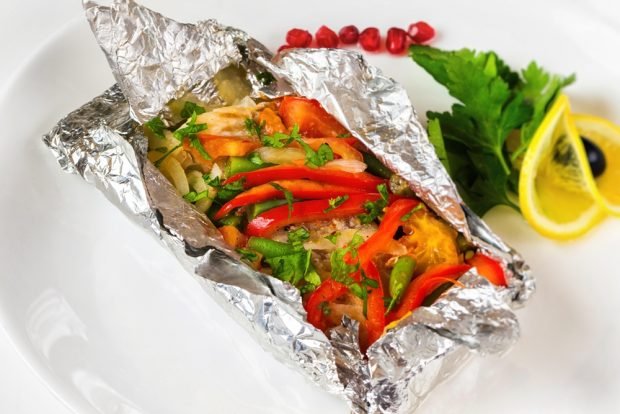 Pollock with vegetables and herbs in foil