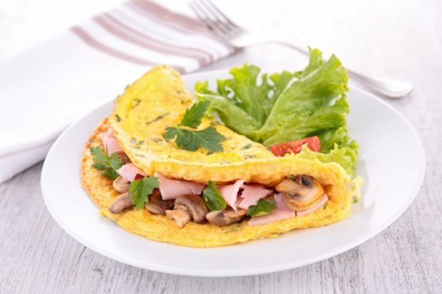 Omelet stuffed with bacon and fried mushrooms