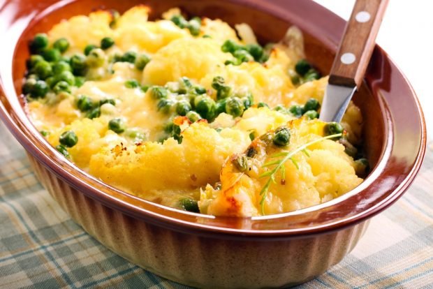 Cauliflower casserole with green peas under cheese 