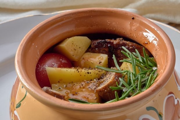 Meat with potatoes and tomatoes in pots