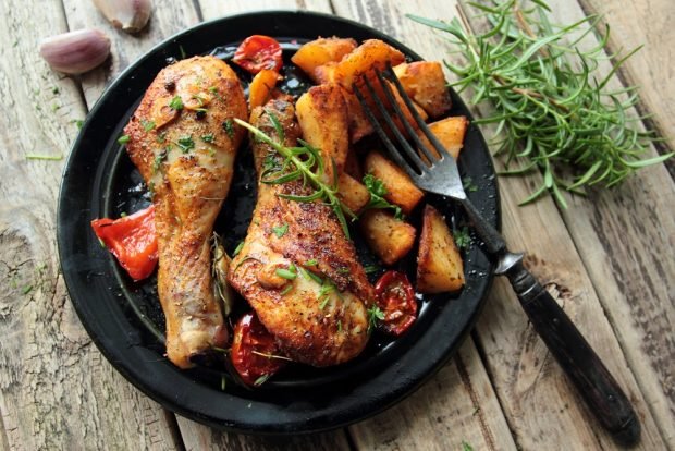 Chicken legs in a frying pan with tomatoes