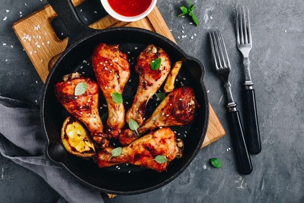 Chicken legs in tomato in a frying pan