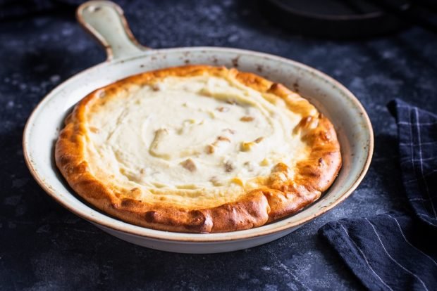 Cottage cheese casserole with sour cream and raisins in a frying pan