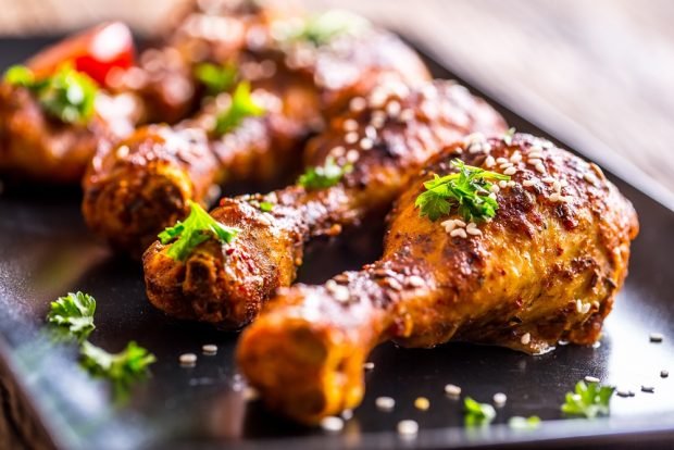 Chicken legs in ketchup in a frying pan