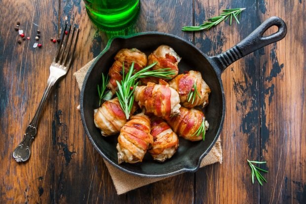 Chicken legs in bacon in a frying pan