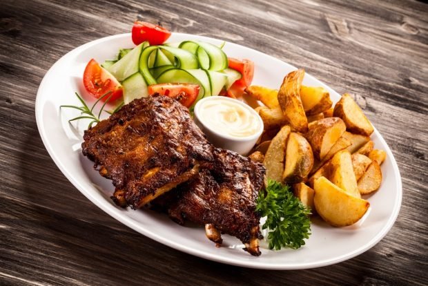 Pork ribs with potatoes on a baking sheet