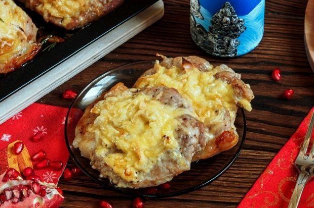 Pork chops with pineapples, onions and cheese in the oven 