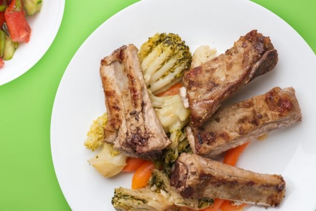 Pork ribs with vegetables in a frying pan