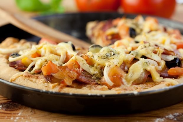 Pizza with salmon in a frying pan