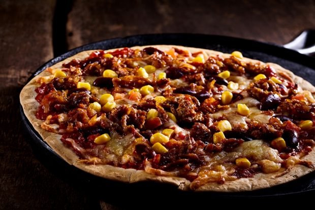 Pizza on thin dough with corn