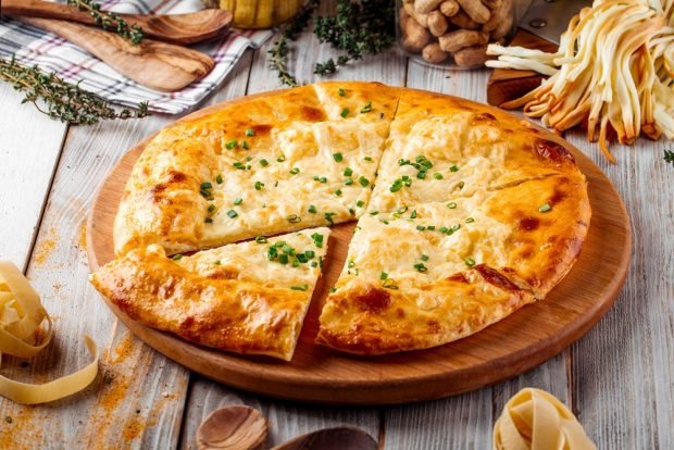 Khachapuri with suluguni and herbs in a frying pan 