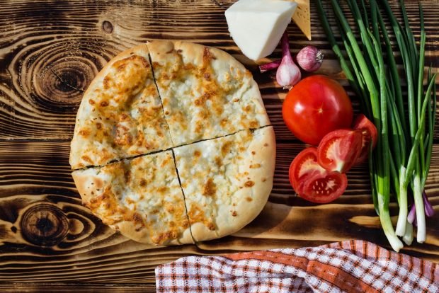 Khachapuri on sour cream with tomatoes and green onions 