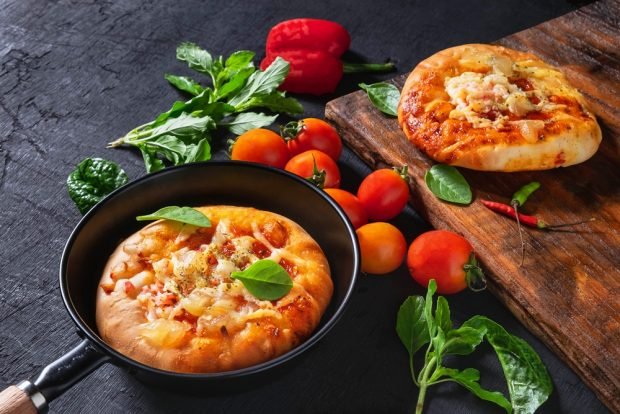 Pizza in a frying pan with mayonnaise and sour cream 